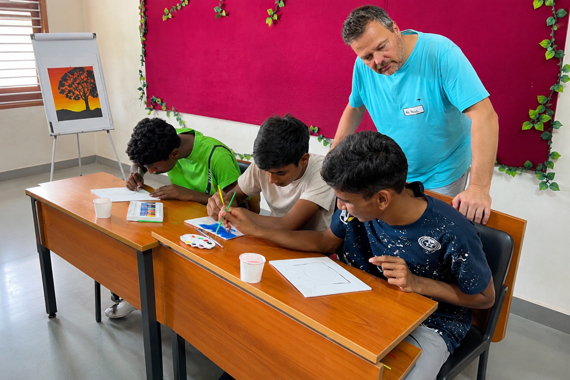 Sing for Hope students drawing at a desk with a teacher